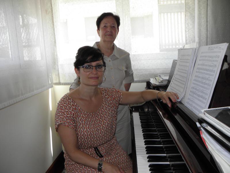 Debora Herrero, etxeko piano isatsdunean eserita, eta Belen Maiza, Kantakaren zuzendaria (2005-2015) eta lehendakaria./Aimar Maiz